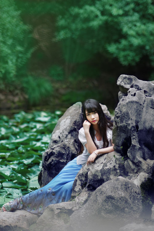 荷花塘假山上的欢快少女