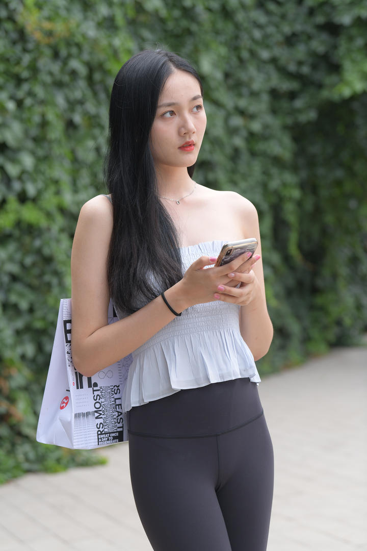 玩手机的街拍瑜伽裤美女写真图片