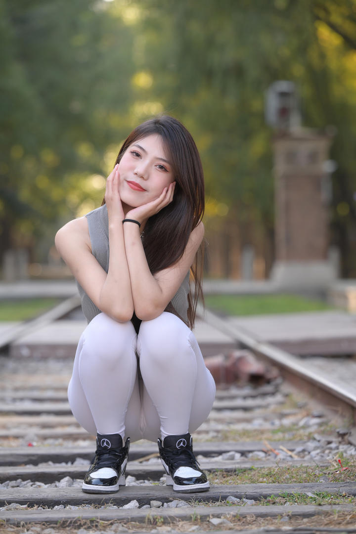 蹲在铁路的紧身裤美女高清手机壁纸图片大全