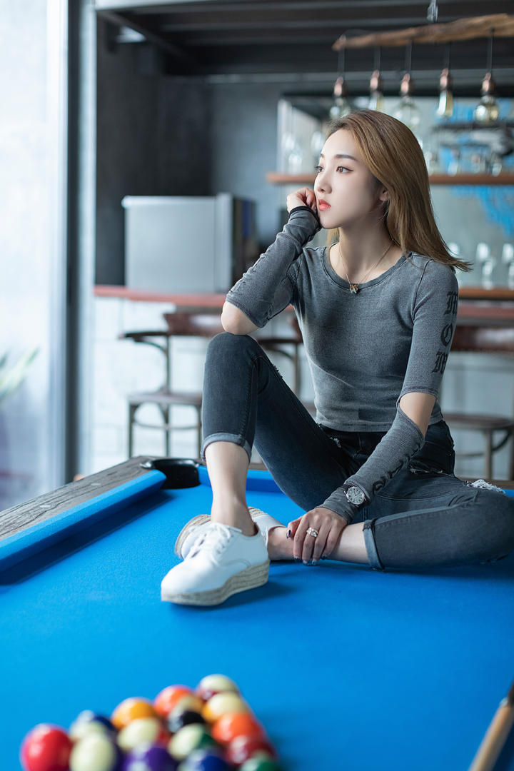坐在台球桌上的高清牛仔裤美女图片