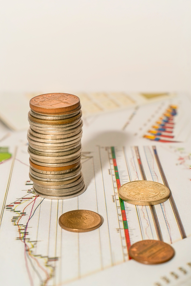 一堆硬币堆叠在一张金融报纸上图片