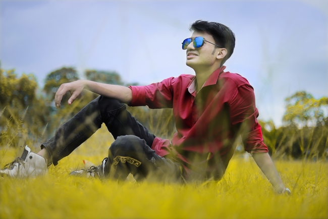 草地戴墨镜帅哥写真图片