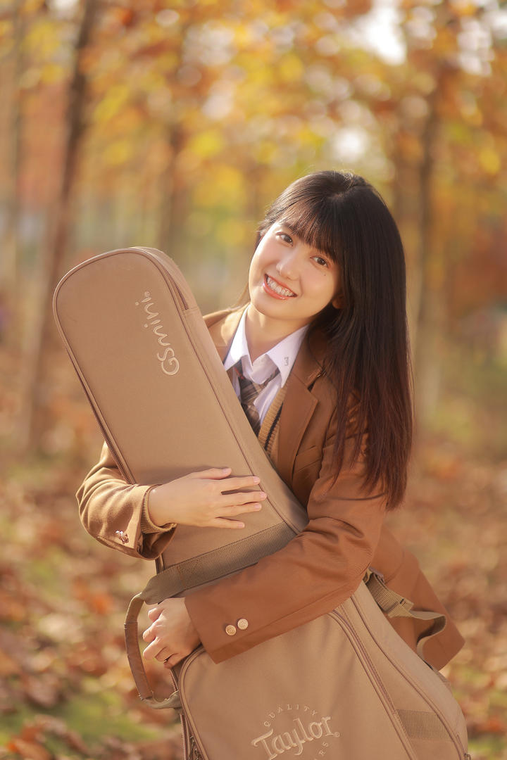 抱着大提琴的日韩可爱清纯女生唯美秋日户外写真图片