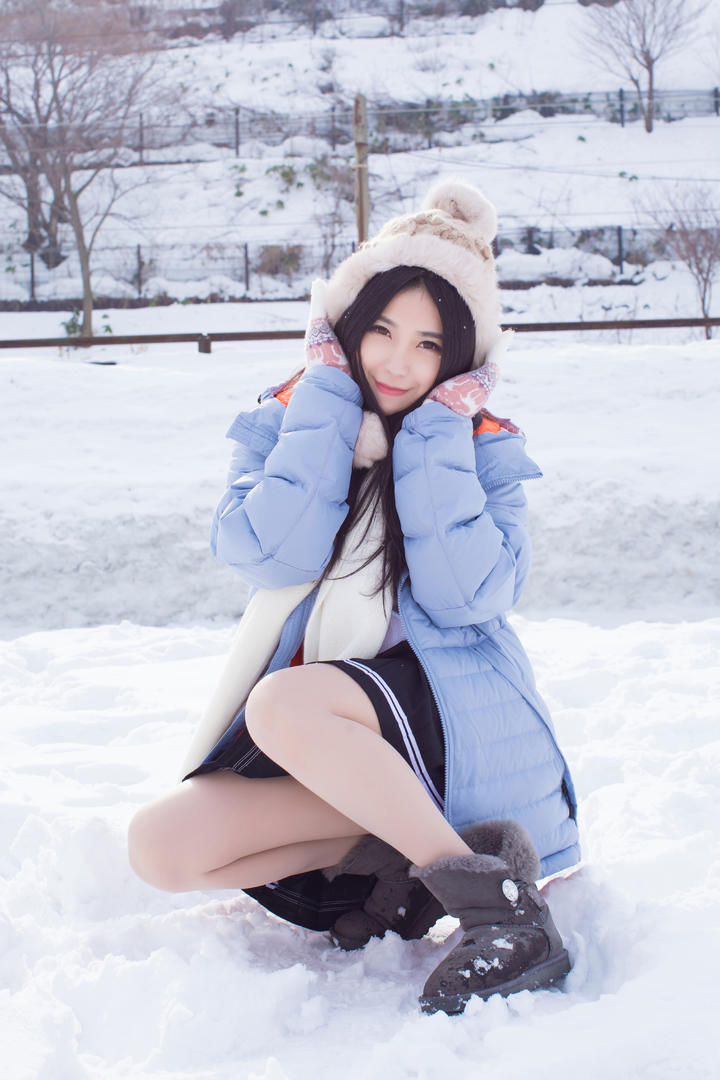 蹲在雪地里的清纯美女图片