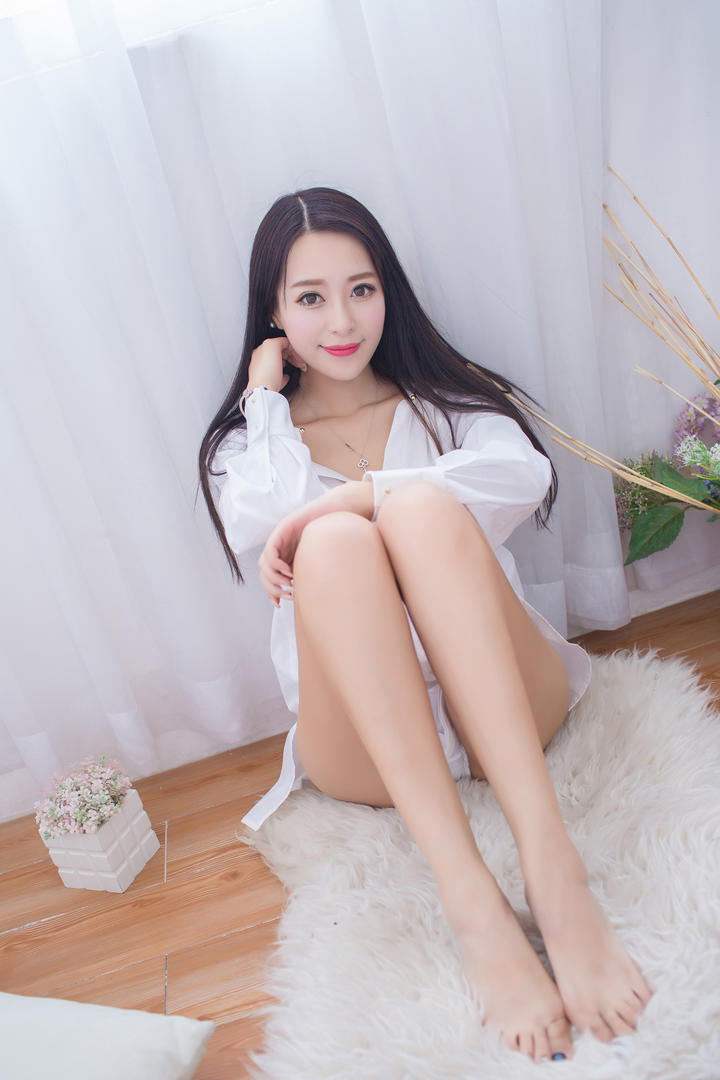 坐在毯子上的性感衬衣美女