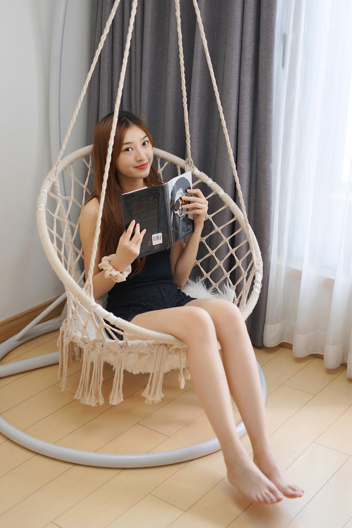 坐在吊椅上看杂志的高清养眼美女壁纸图片