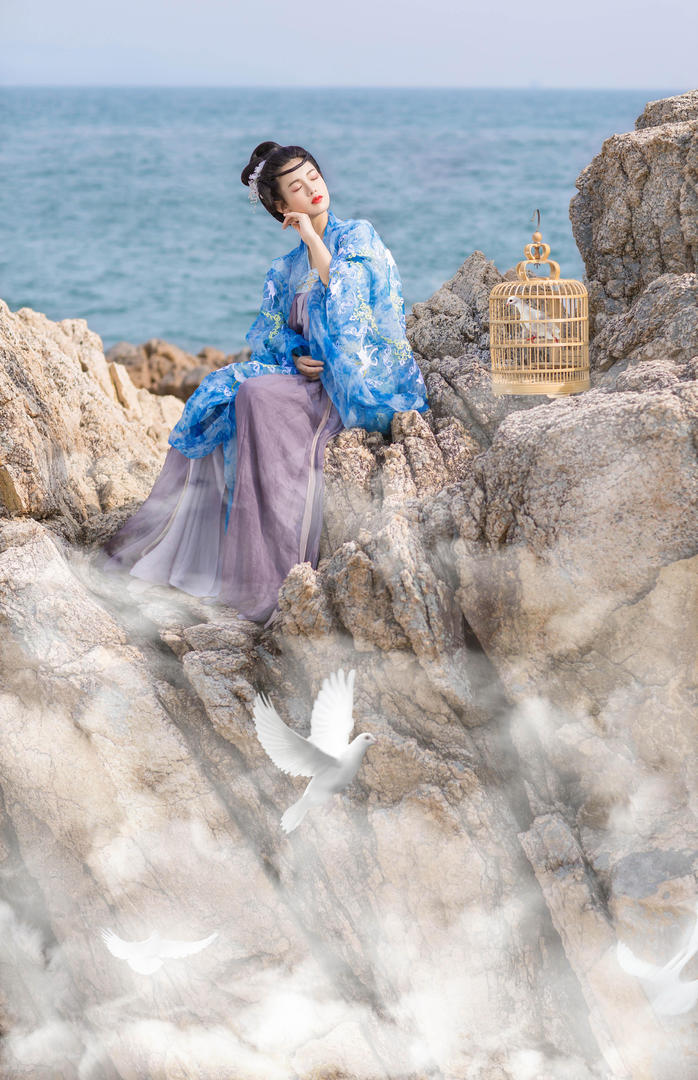 坐在海边礁石上的唯美古装美女艺术写真图片