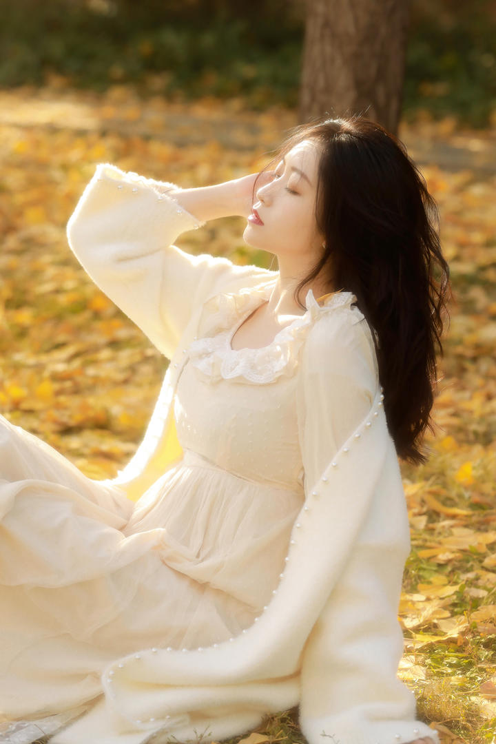 坐在草地上的白衣气质美女图片大全