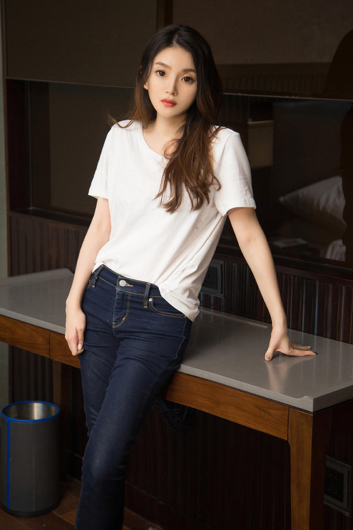 靠在桌子上的高清牛仔裤美女图片