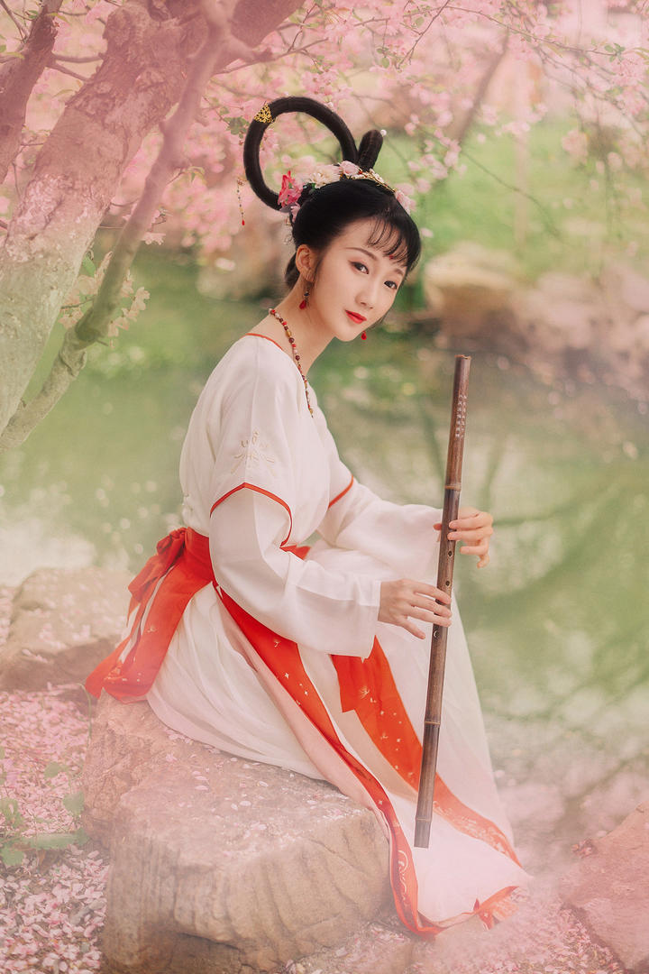 坐在石头上吹笛子的古装清纯美女图片