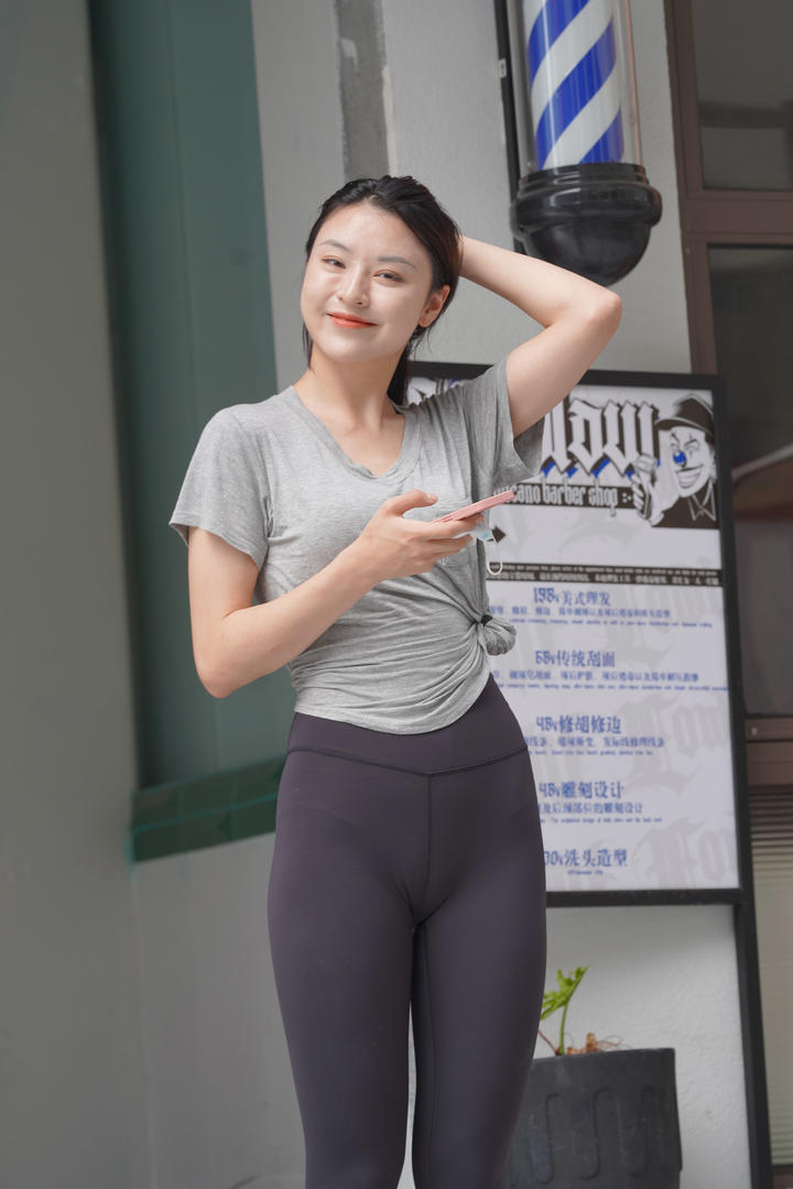 玩手机的街拍瑜伽裤美女高清壁纸图片