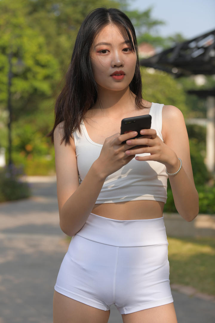 街拍玩手机的紧身裤邻家女孩清纯女生壁纸图片大全