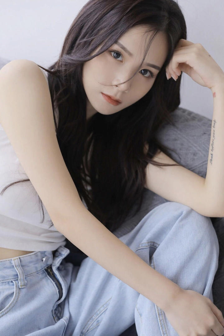 坐在沙发上的清纯牛仔裤女生写真图片