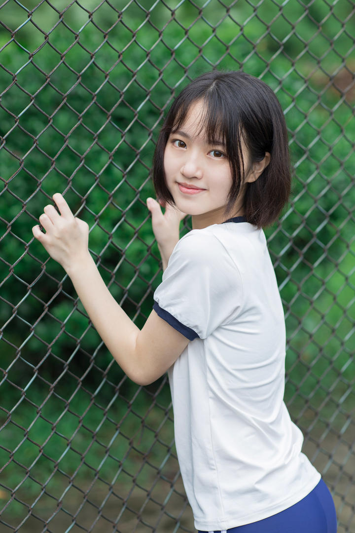 趴在铁丝网上的短发初中女生二妹写真图片