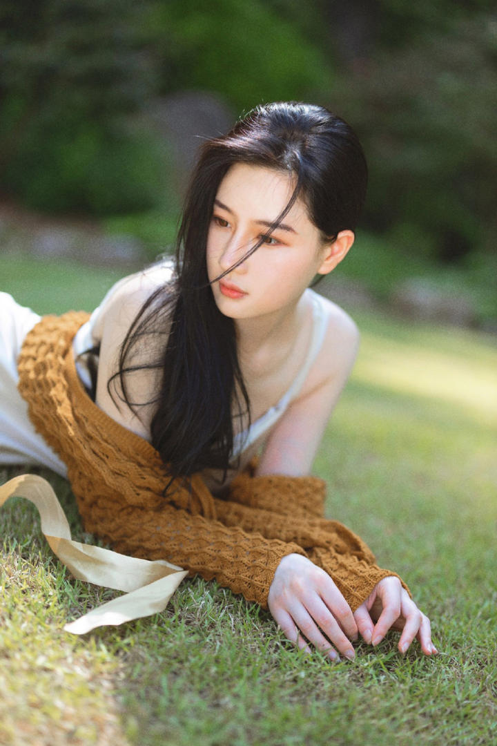 趴在草地上的清纯美女写真图片