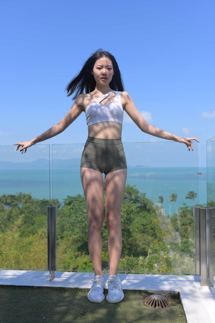 穿紧身热裤的清纯长腿女生海边度假旅拍写真图片