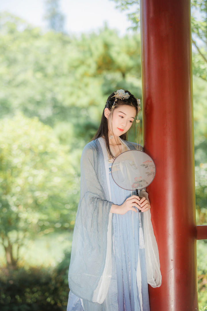 靠在红色柱子上的古风美女艺术写真图片