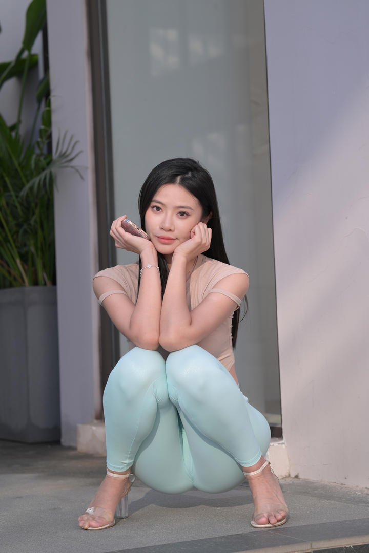 蹲在街上的蜜桃臀瑜伽裤美女模特图片