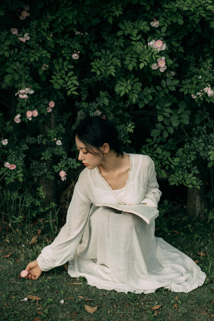 采花的白衣美女户外人像艺术摄影图片