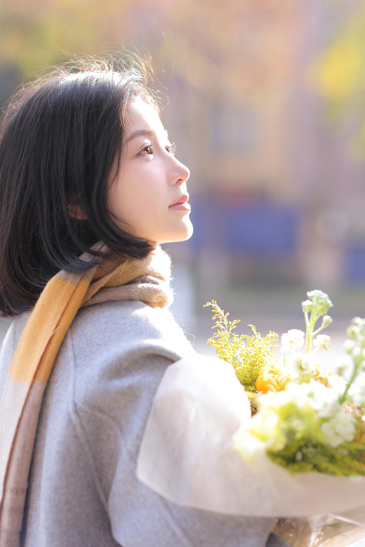 捧着鲜花的清纯短发女孩高清侧脸写真图片