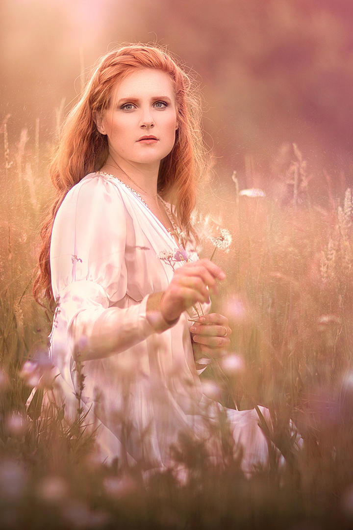 坐在草丛中的欧美美女摄影图片