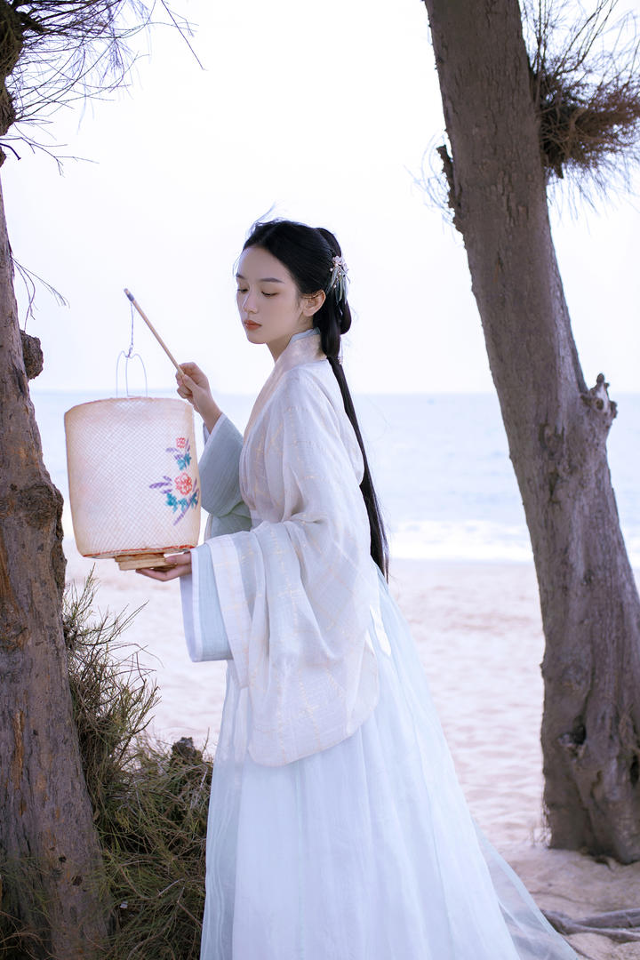 沙滩上打着灯笼的古典白衣美女艺术摄影图片