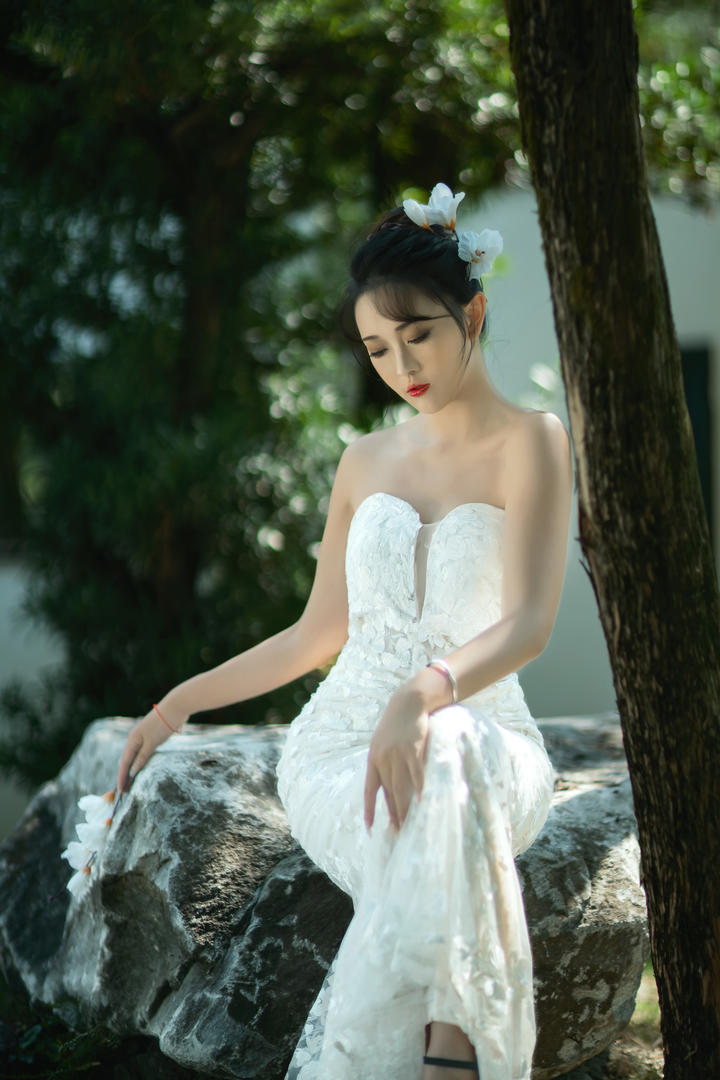 坐在石头上的极品美女低胸婚纱照拍摄图片