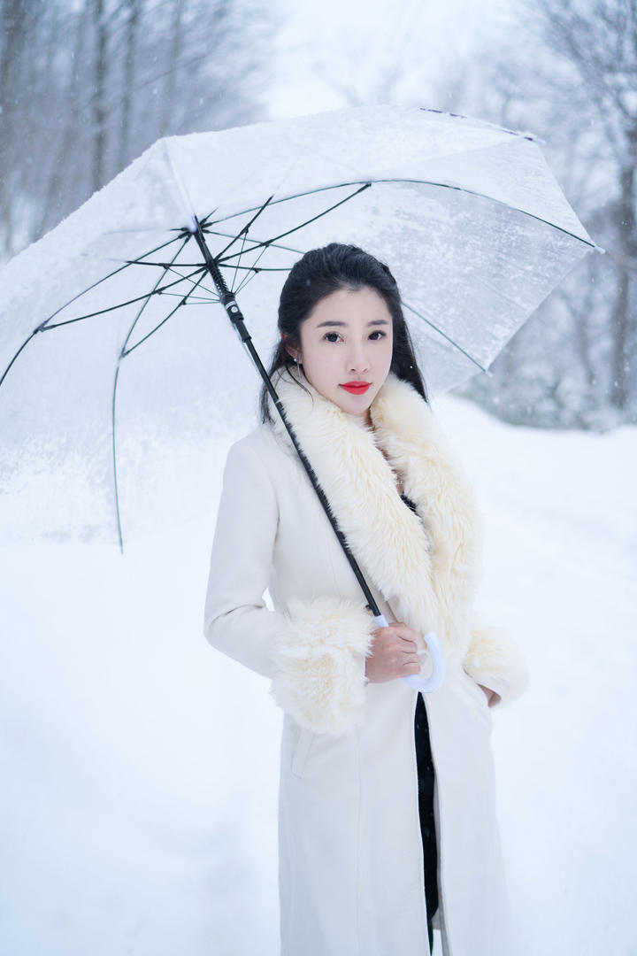 撑着伞站在雪中的气质女生图片