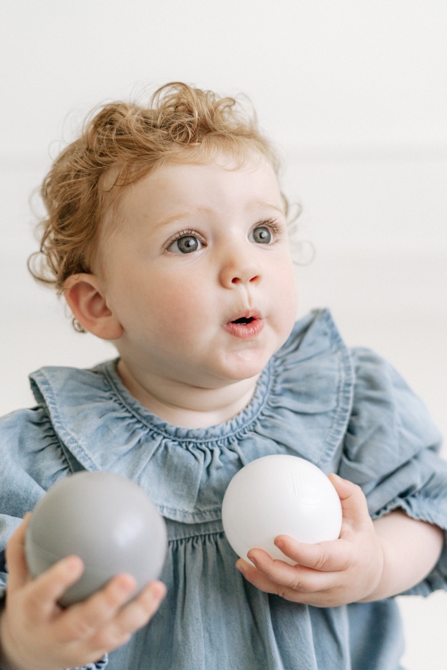 抱着两个球的萌娃图片