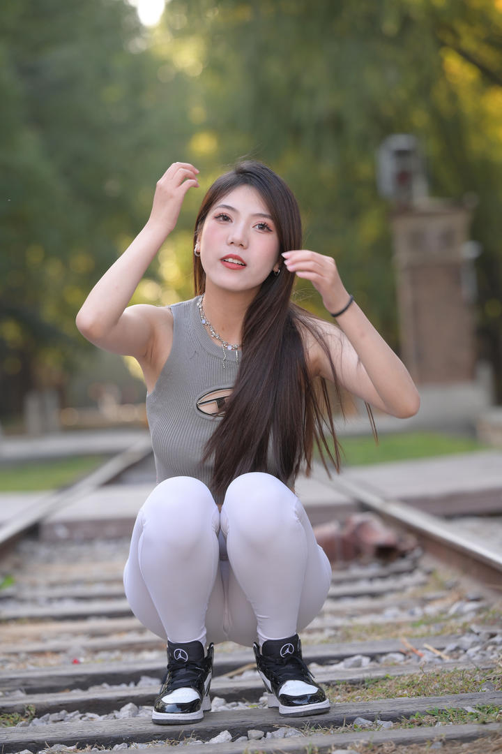 蹲在铁路上的紧身瑜伽裤美女高清美女街拍图片