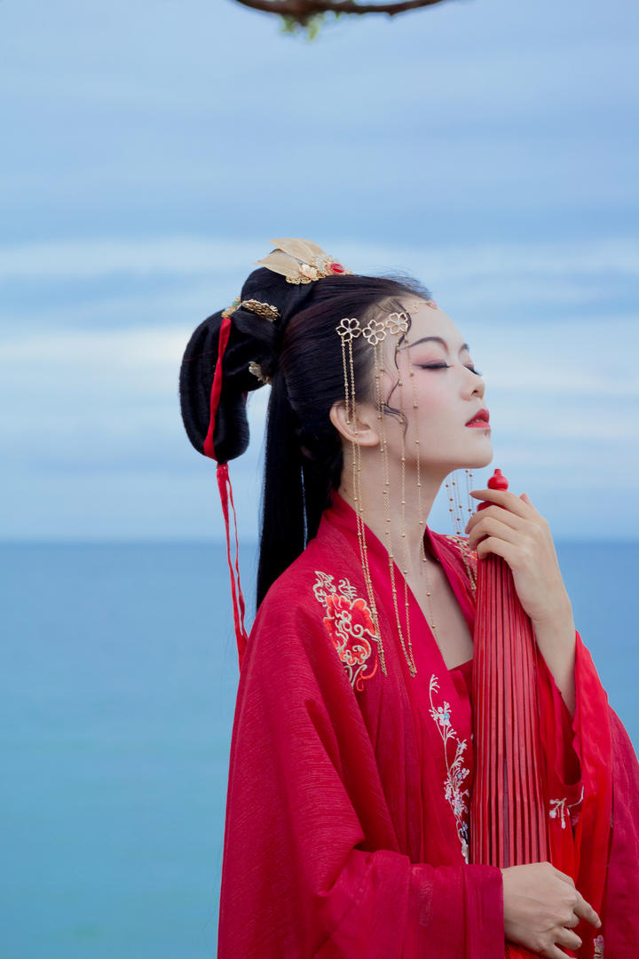 拿着油纸伞的红色古装美女航子海边人像摄影图片