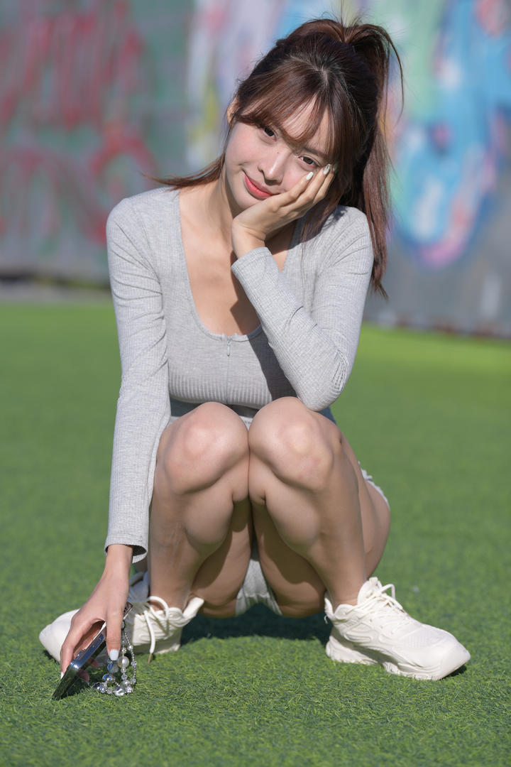 蹲在操场上的体操服美女校花图片