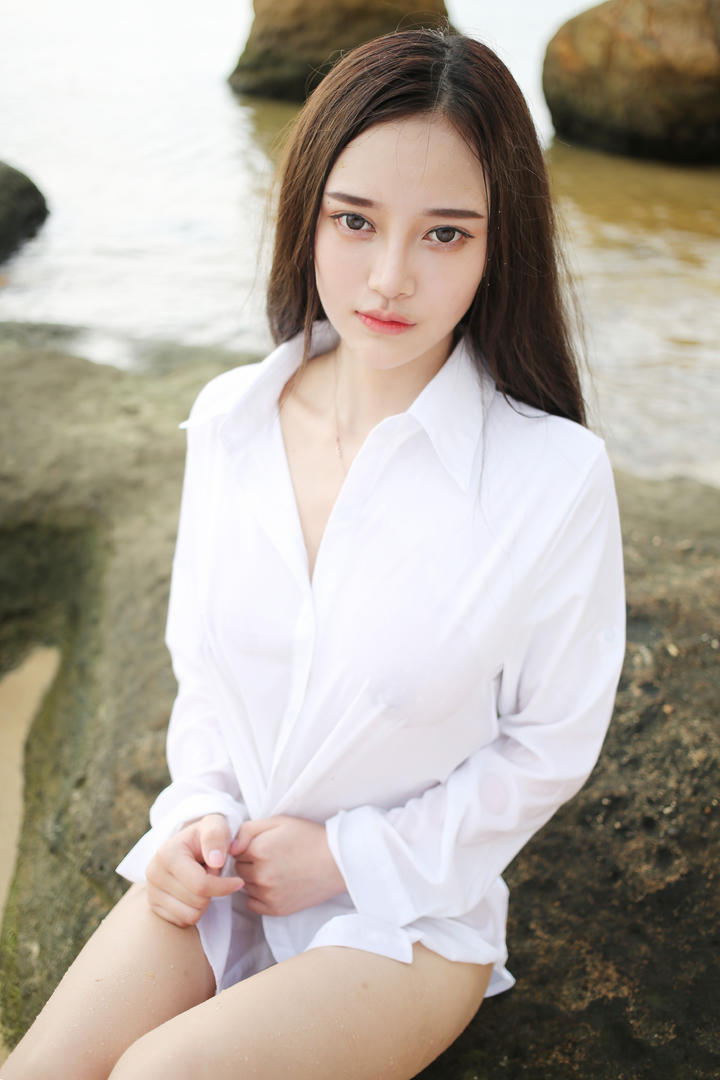 穿着衬衣坐在岩石上的极品女神图片