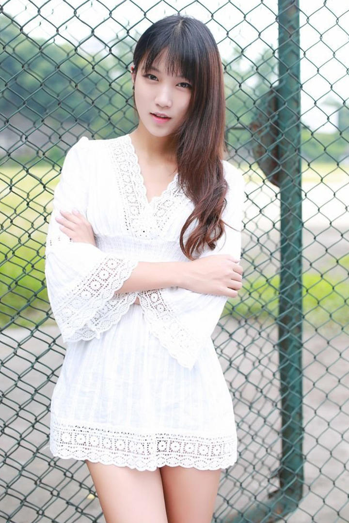 靠在铁丝网上的清纯美女写真