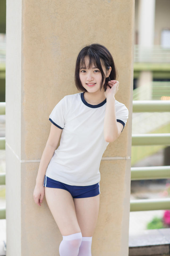 靠在柱子上的高清可爱短发发型女学生写真图片