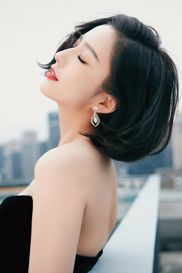 靠在栏杆上的新疆美女明星佟丽娅写真图片