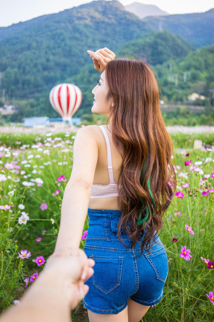 手牵手走在花丛中的网红主播王明明户外写真图片