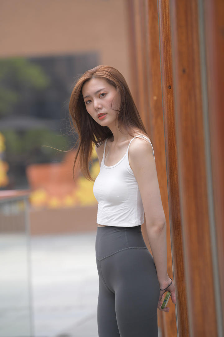 穿白色背心的紧身裤美女模特街拍图片