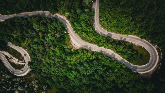 绿色森林蜿蜒盘旋公路鸟瞰图摄影