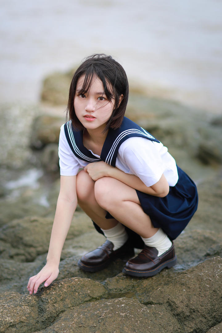 蹲在礁石上的初中女生穿校服写真图片