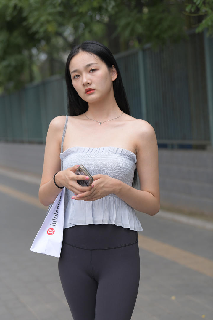 背着包包的街拍紧身裤美女写真图片