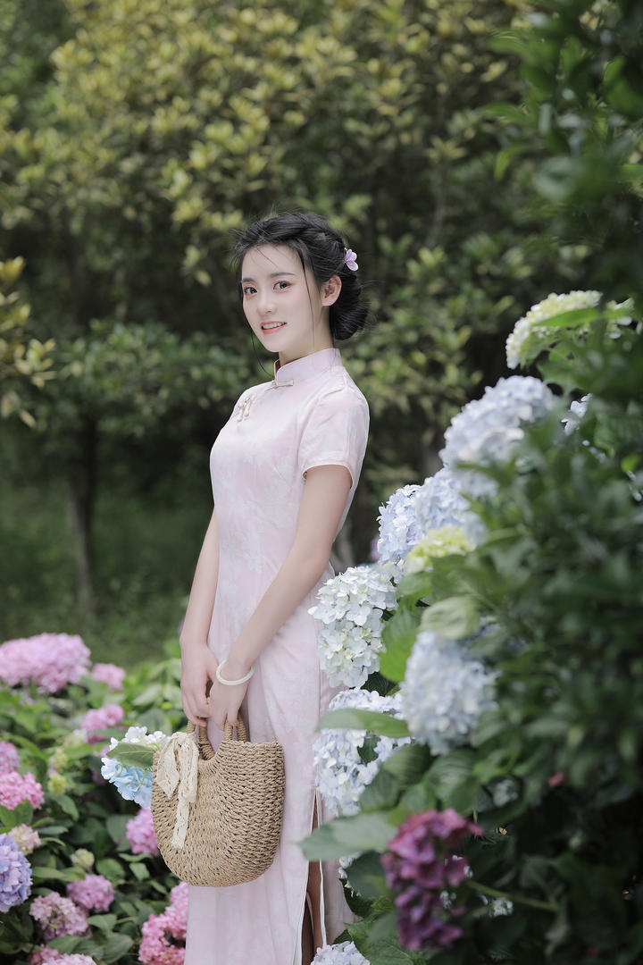 花园里赏花的高级气质旗袍美女艺术照图片