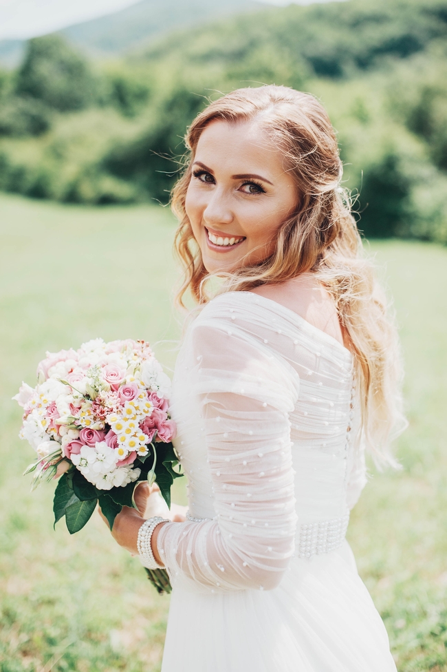 户外草地捧着手捧花美女婚纱图片