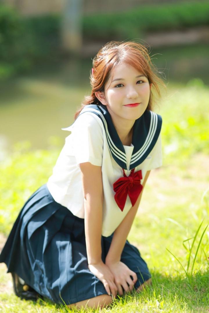 跪在草地上的清纯美女制服美女写真图片