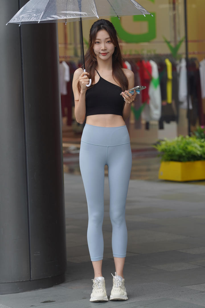 最新99精品国内街拍紧身裤美女打雨伞图片