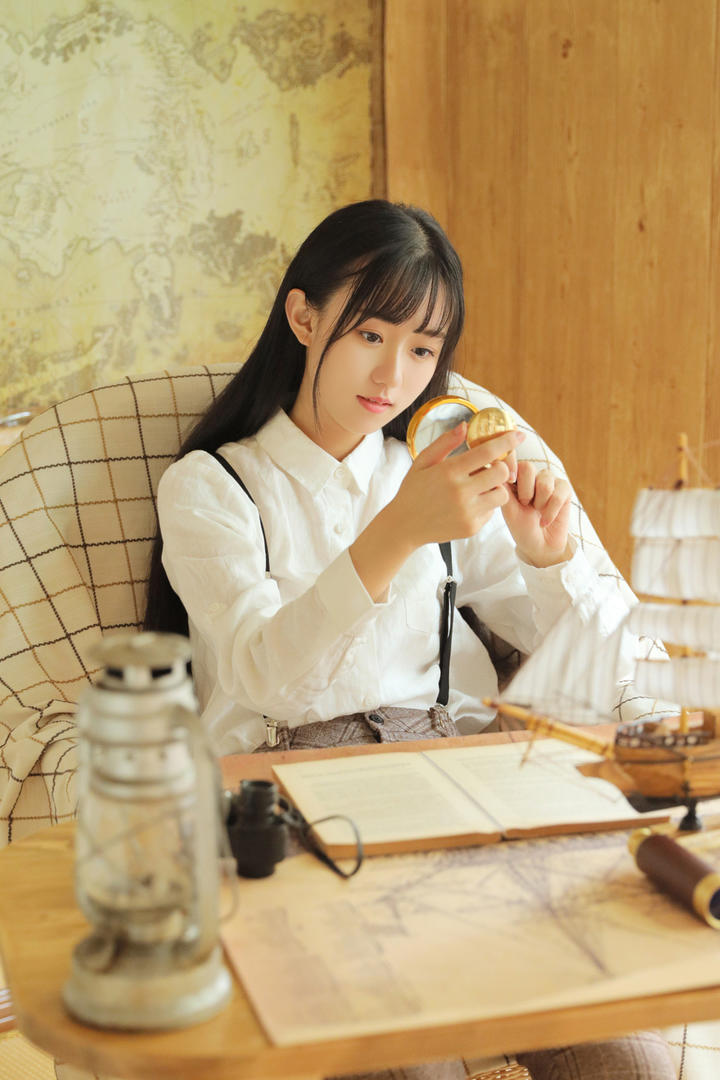 拿着放大镜观看的气质美女