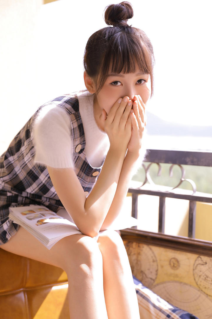 阳台上看书的齐刘海发型美女写真图片