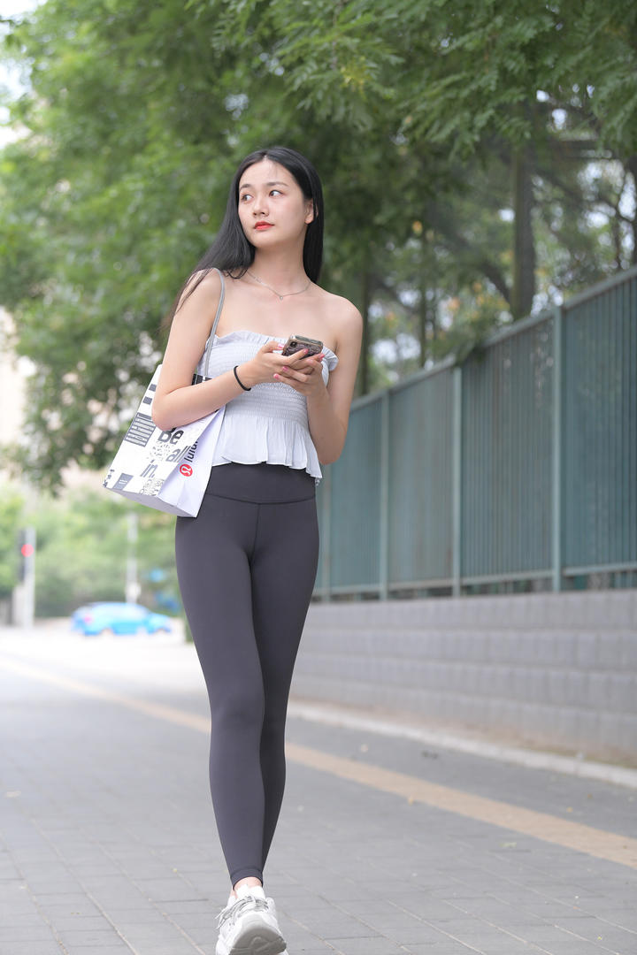 走路玩手机的街拍紧身裤美女图片