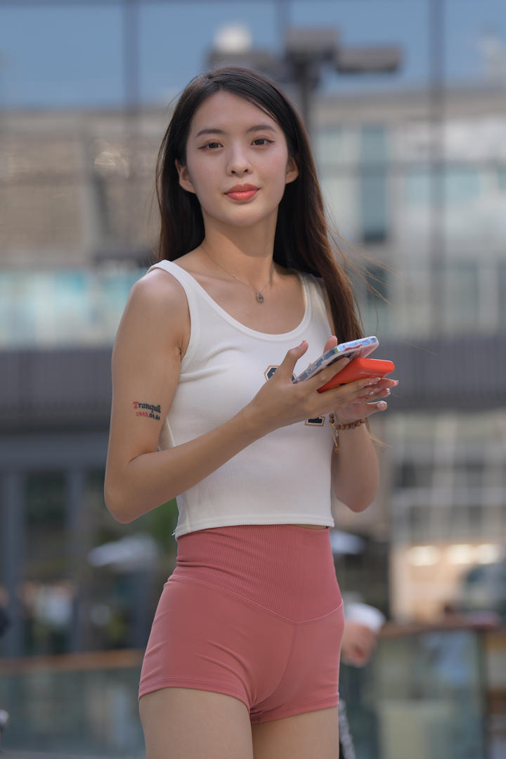 含羞草街拍玩手机紧身裤美女图片