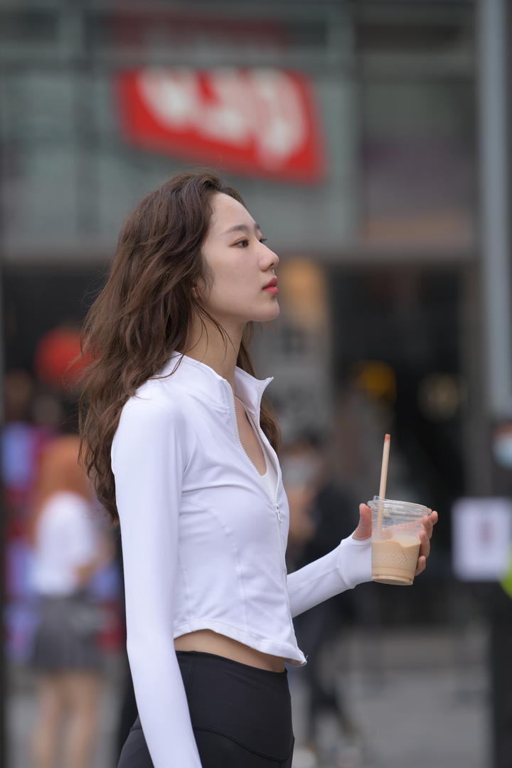 喝奶茶的女白领穿街拍紧身裤美女图片